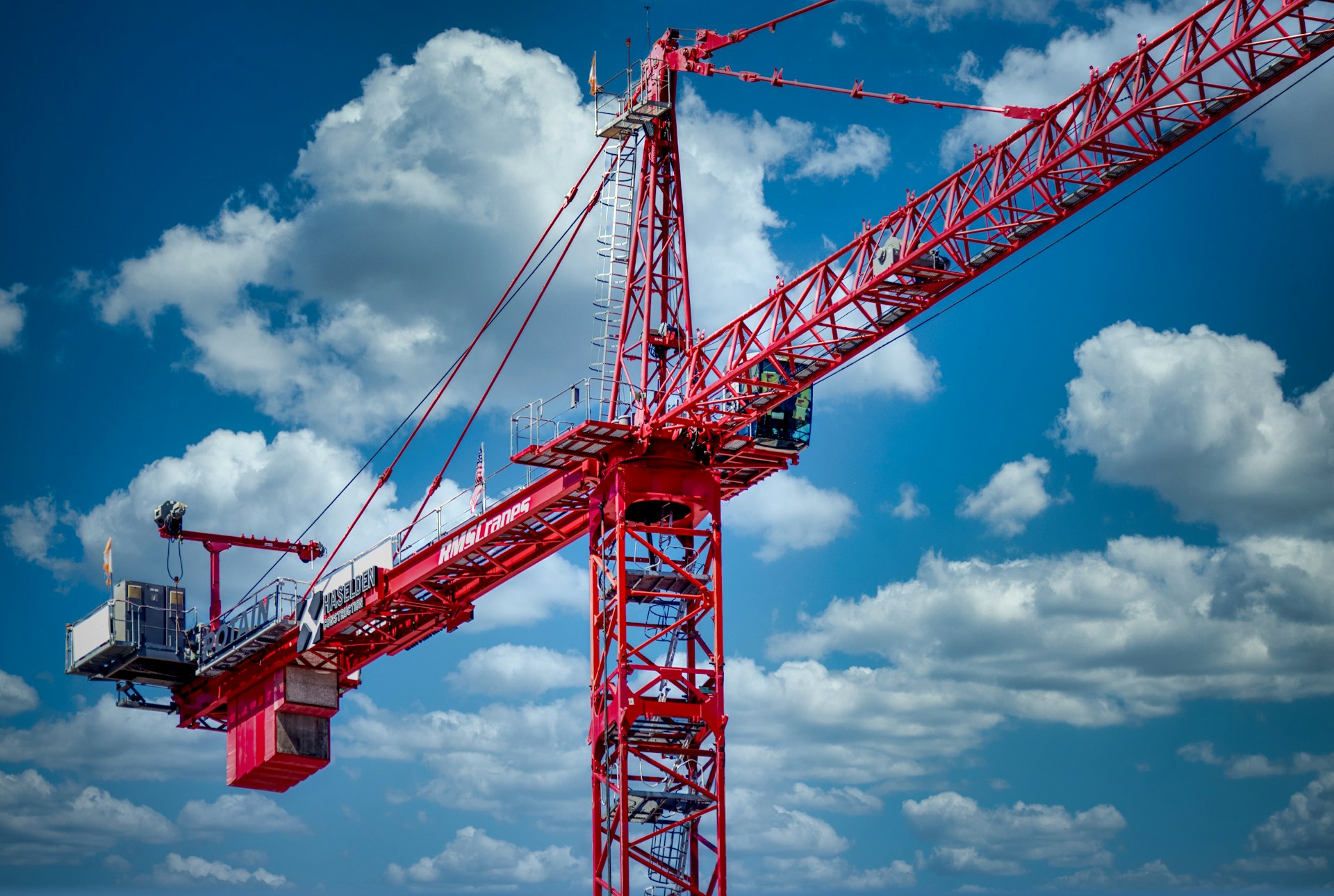 a large red crane sitting on top of a sandy beach